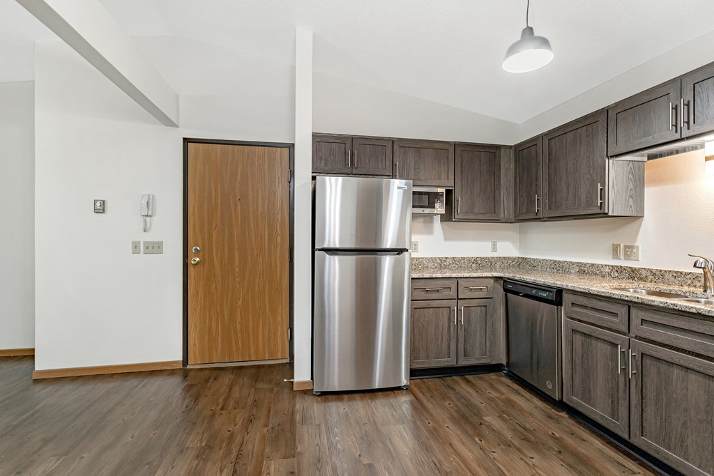 an empty kitchen with a stainless steel refrigerator
