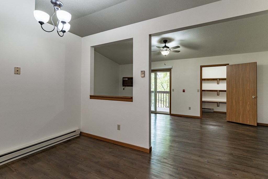 an empty living room with white walls and wood flooring
