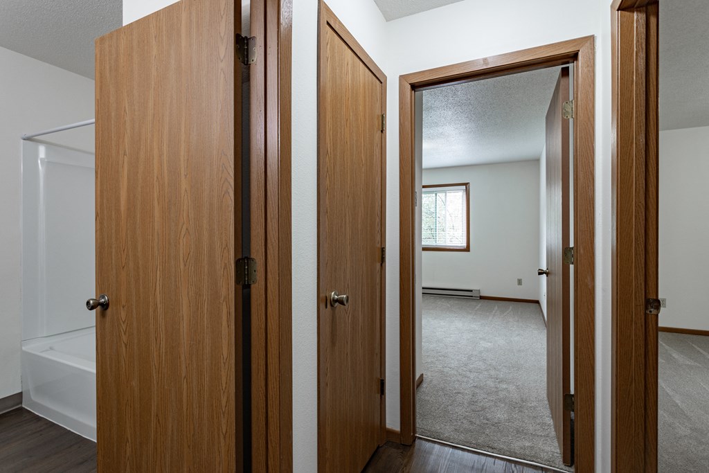 an open door into a bedroom and a mirror in a house