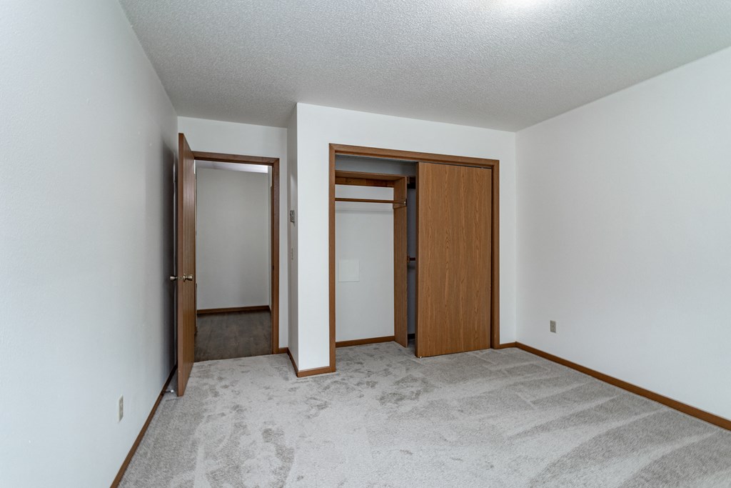 an empty living room with white walls and wood doorways