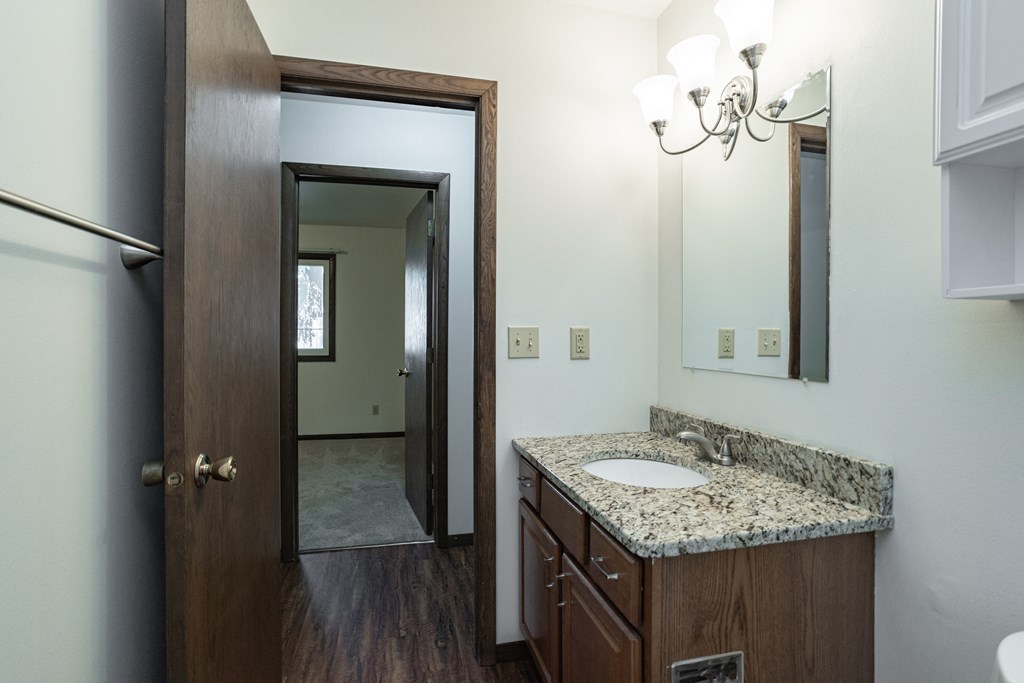 a bathroom with a sink and a mirror and a door to a closet