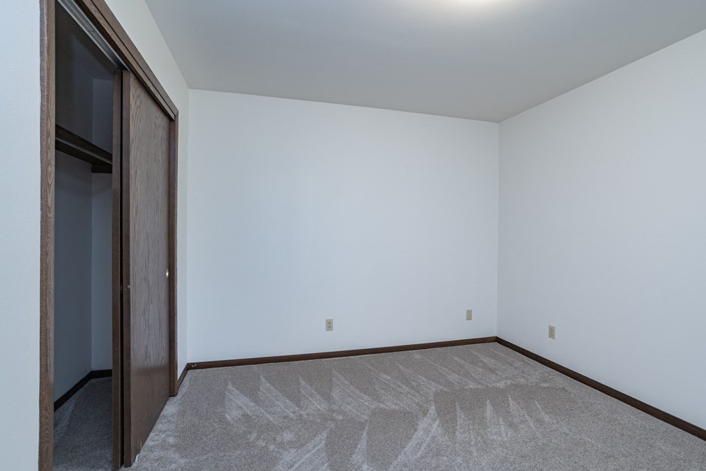 an empty room with a door to a closet