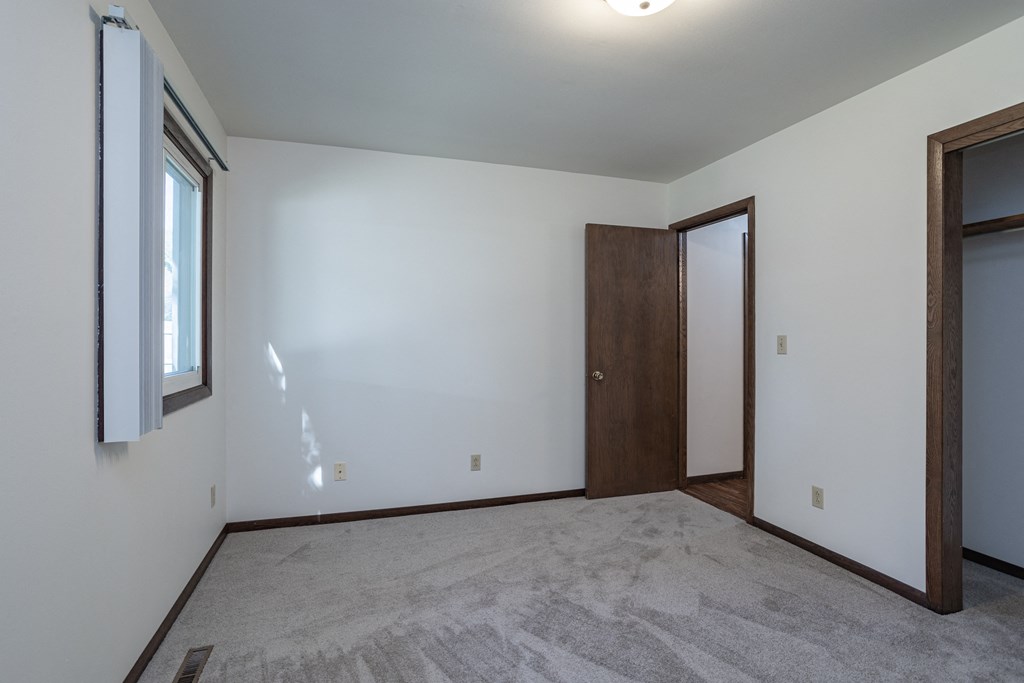 an empty living room with white walls and a wooden door