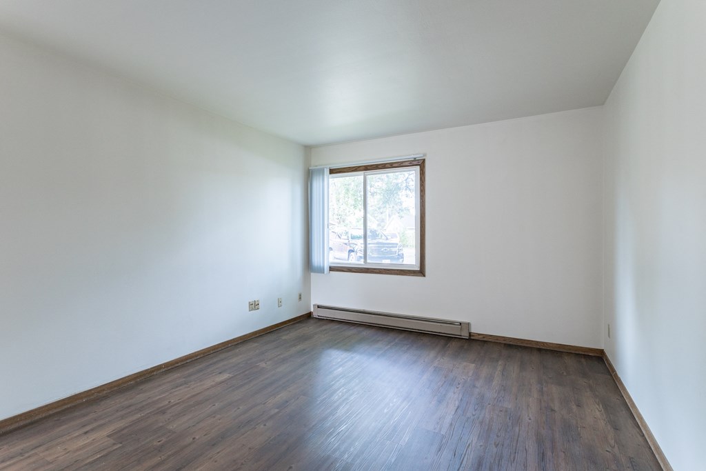 an empty room with white walls and a window