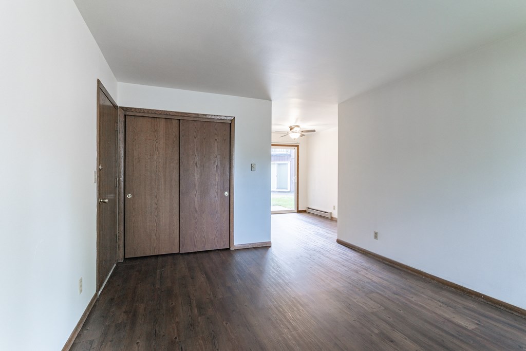 an empty living room with white walls and wood flooring