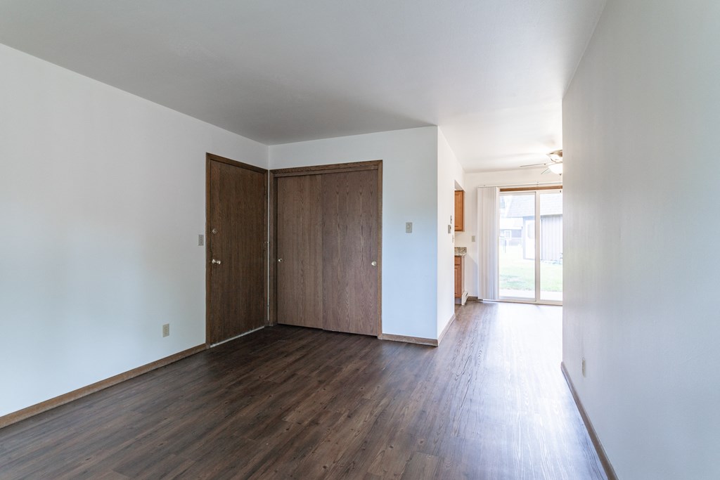 an empty living room with white walls and wood flooring