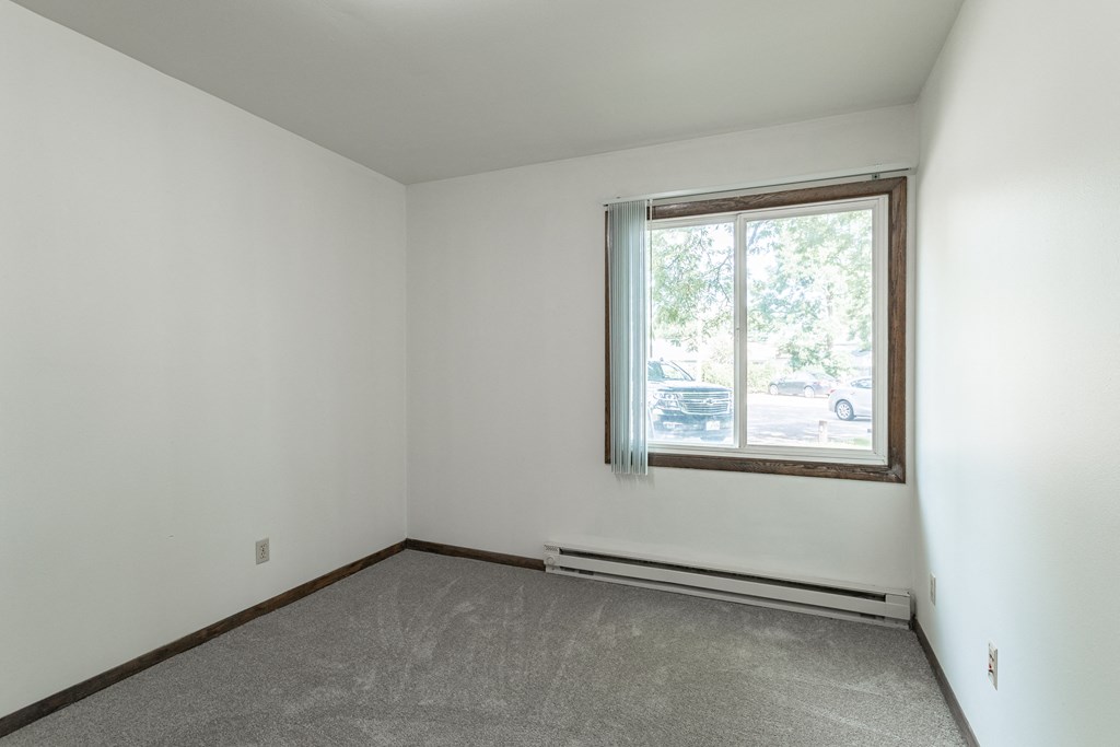 an empty room with a window and a carpet