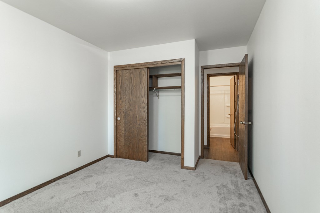 an empty room with two doors and a closet