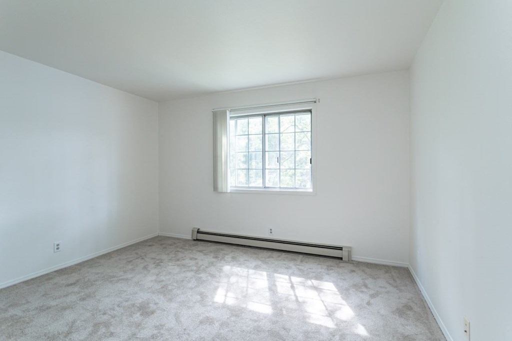 a white room with a window and carpet