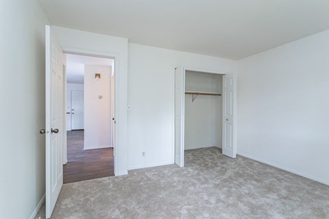 an empty bedroom with white walls and a closet