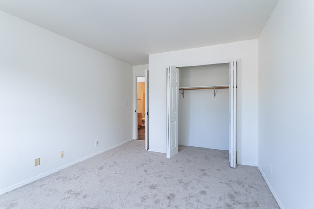 an empty bedroom with white walls and a closet