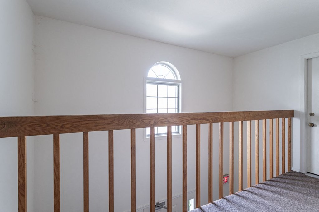a loft with a wooden railing and a window