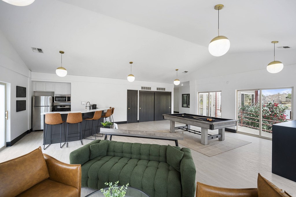 a living room with a pool table and a green couch