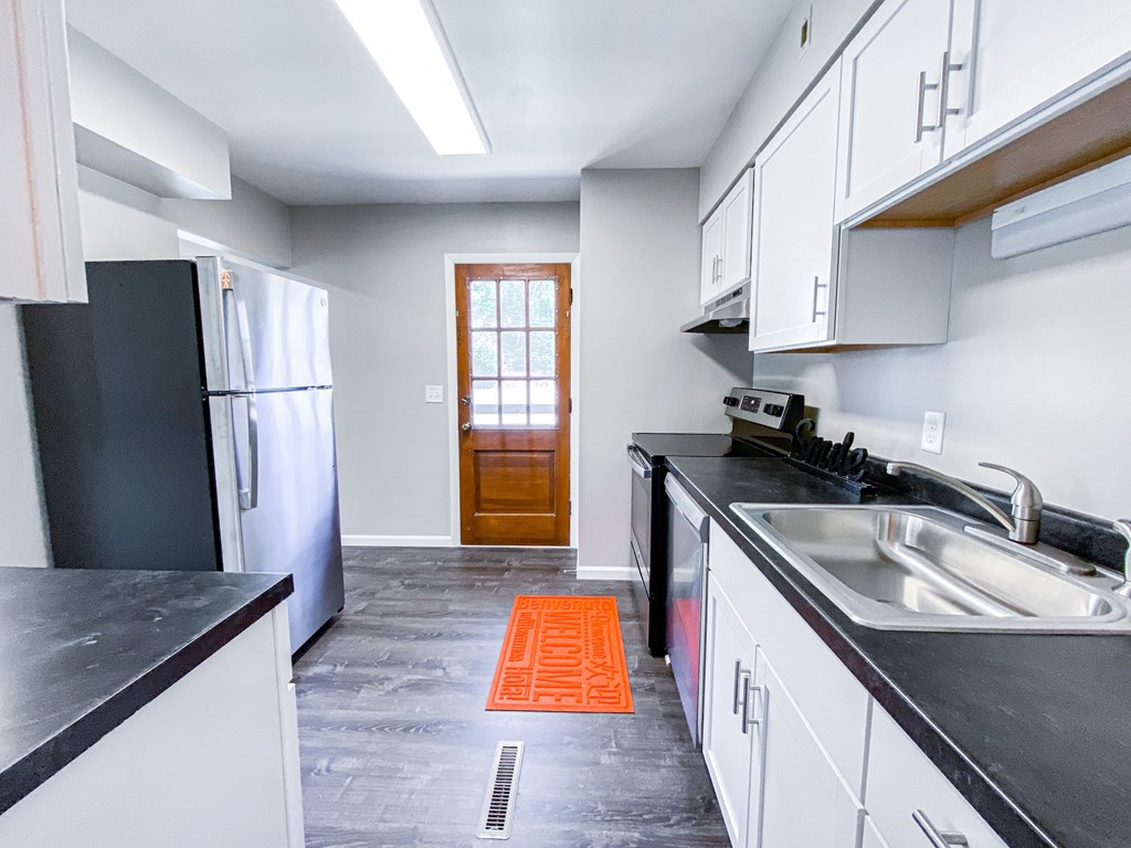 A kitchen with black countertops and white cabinets.