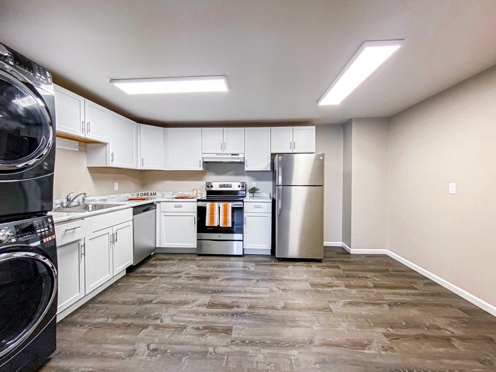 a kitchen with white cabinets and stainless steel appliances