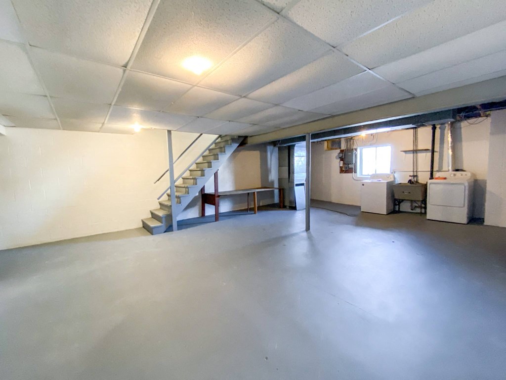 the inside of an empty garage with a staircase in the corner