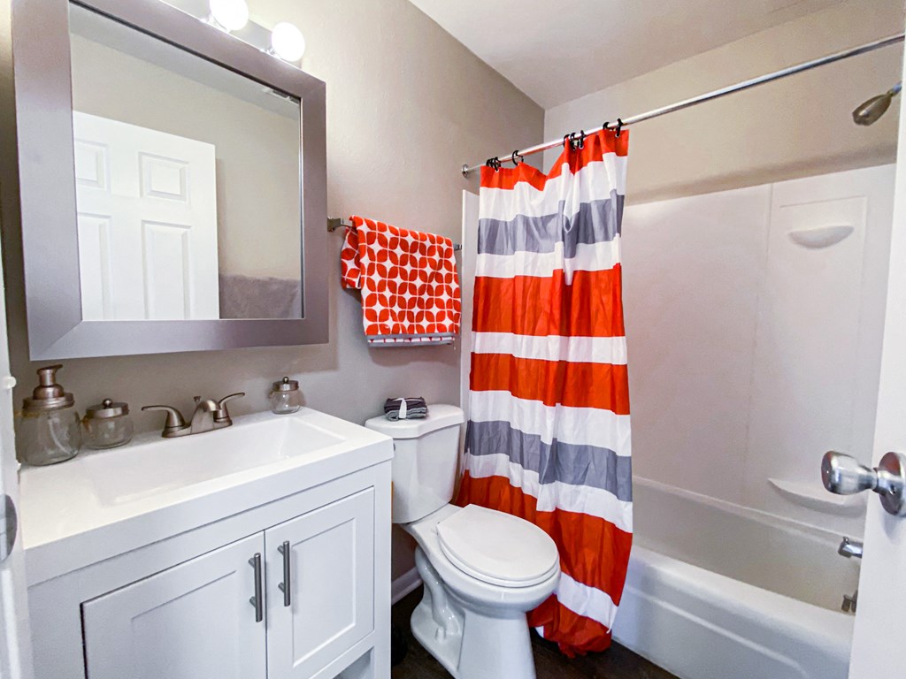 a bathroom with a white sink and toilet and a shower curtain