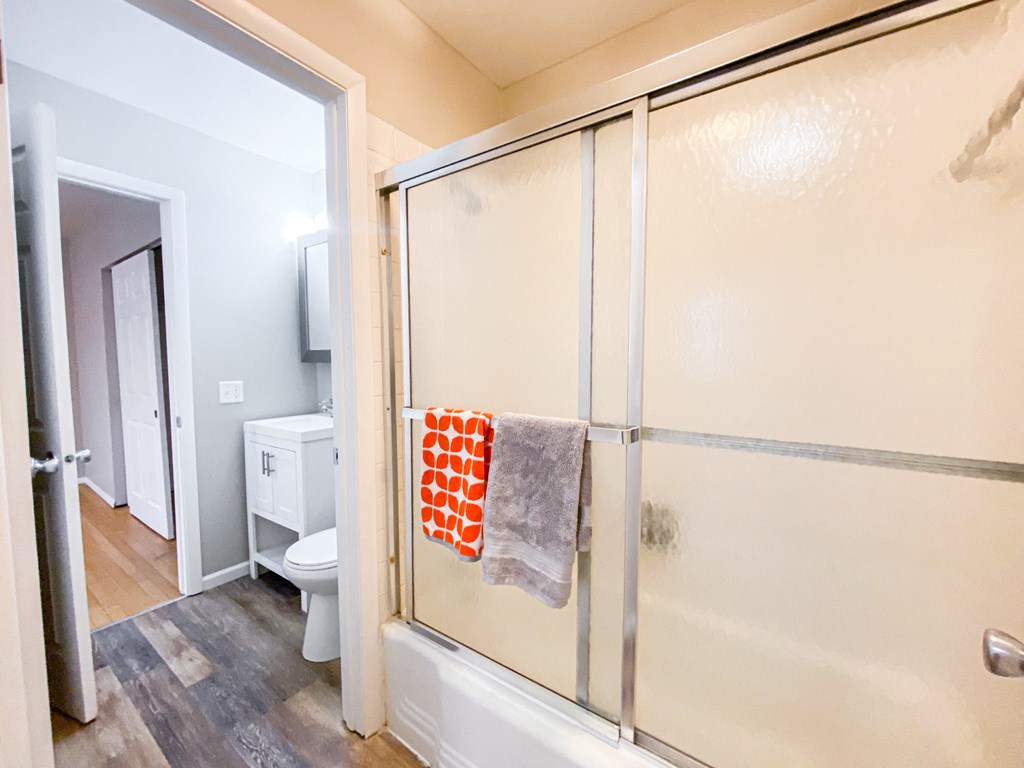 a bathroom with a shower and a toilet and a sliding glass door