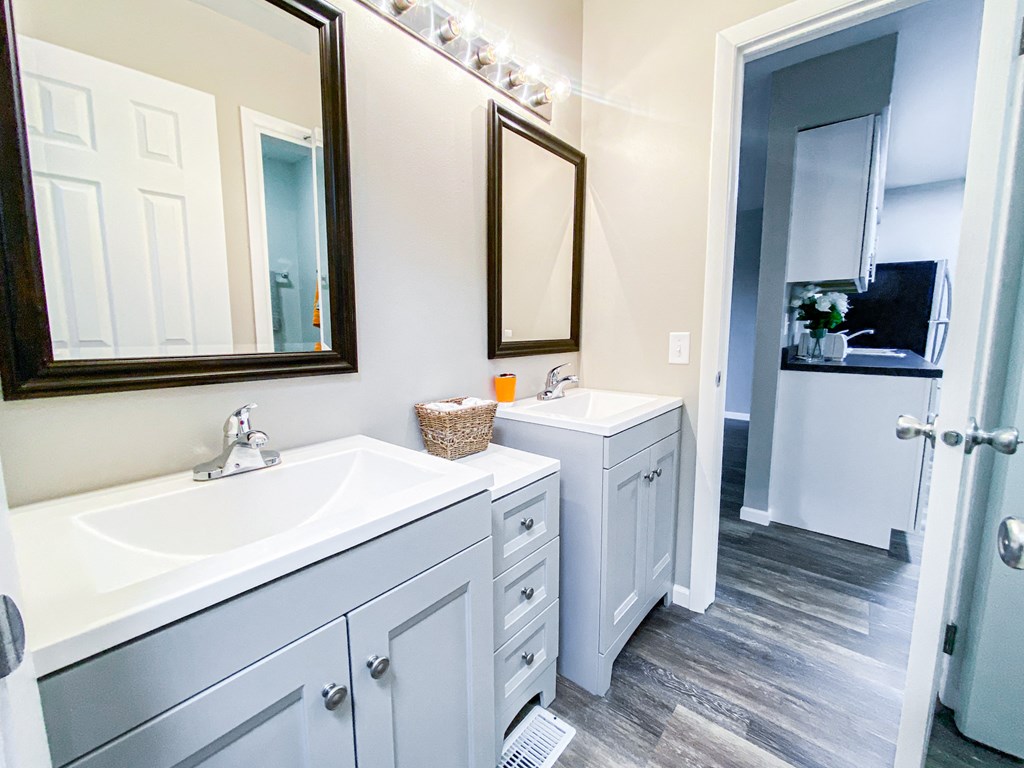 a bathroom with white cabinets and a sink and a mirror