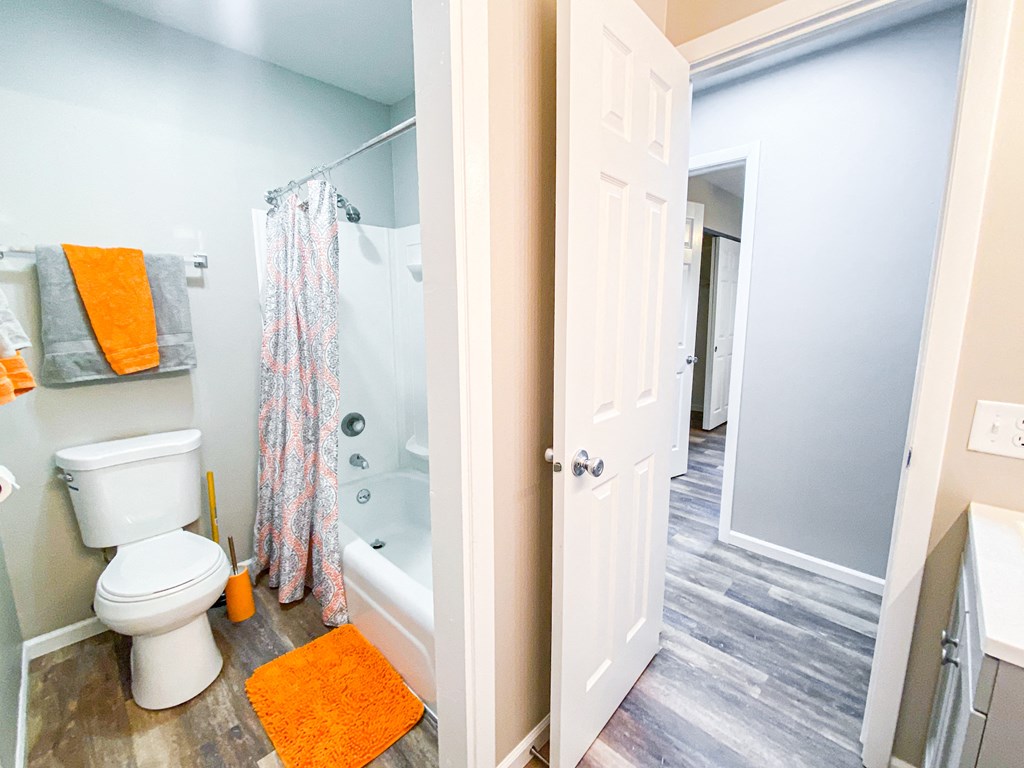 a bathroom with a toilet and a shower and a door open
