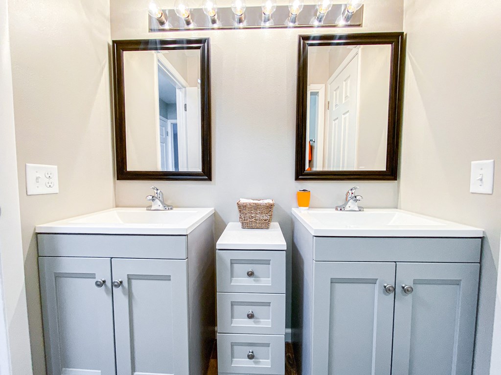 a bathroom with two sinks and two mirrors