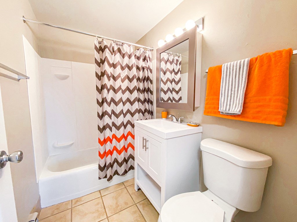 a bathroom with a white toilet and a shower and a sink