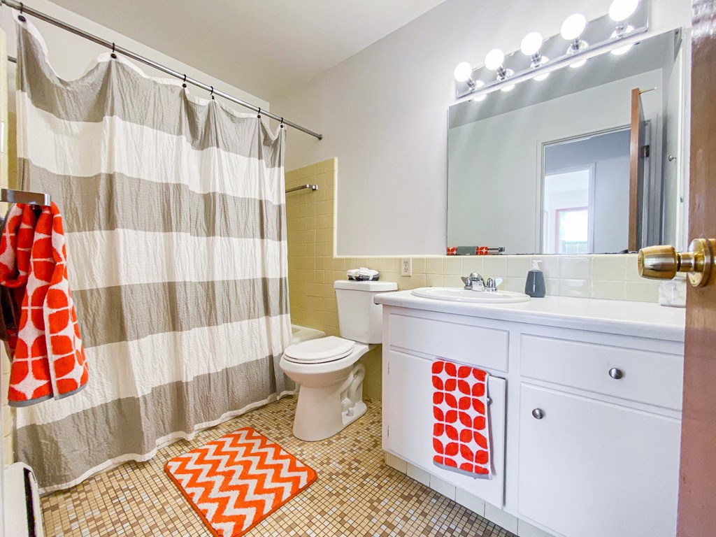 a bathroom with a shower curtain and a sink and a toilet