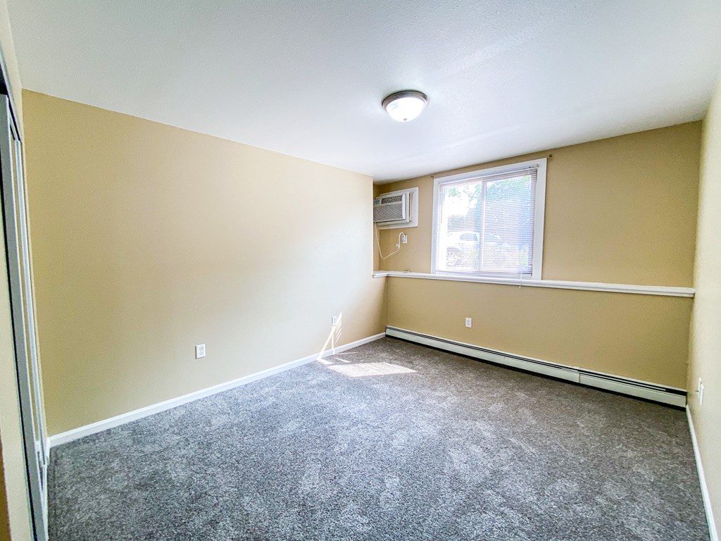 an empty room with carpet and a window
