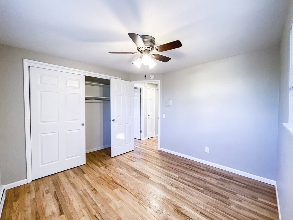 an empty living room with blue walls and a ceiling fan