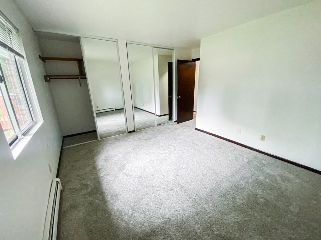 an empty room with white walls and a carpeted floor