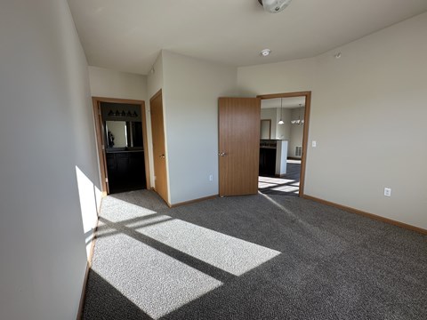 A room with a carpet and a door.
