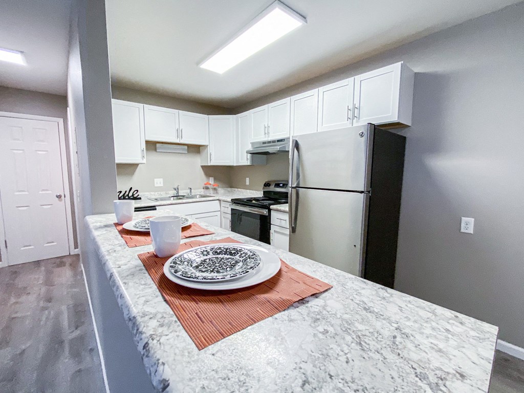 a kitchen with white cabinets and stainless steel appliances and a granite counter top