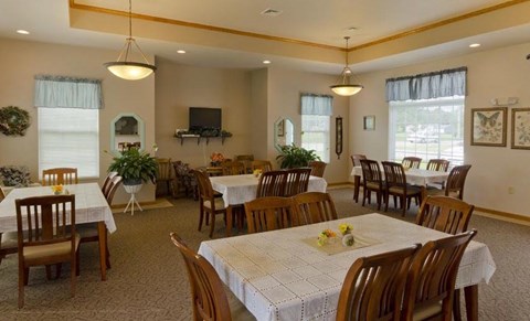 A dining room with tables set for a meal.