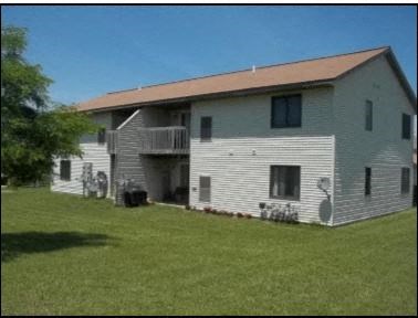 a white house with a red roof on a lawn