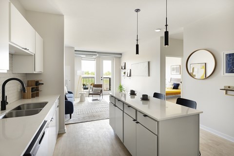 A modern kitchen with white cabinets and a large island.