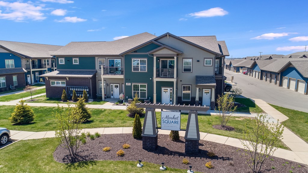 a large house with a sign in front of it on a sidewalk