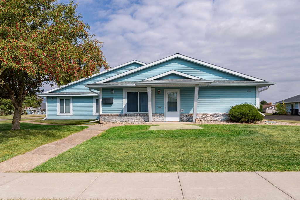 a blue house with a tree in front of it