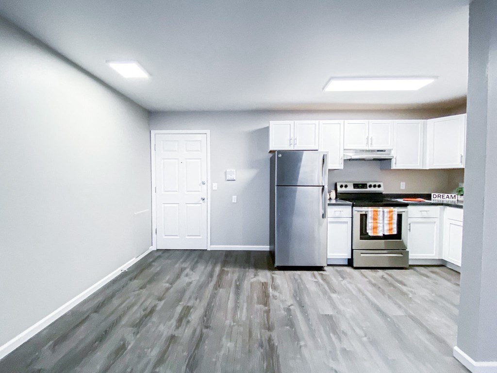 an empty kitchen with white cabinets and stainless steel appliances