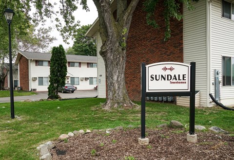 A sign that says Sundale in front of a house.