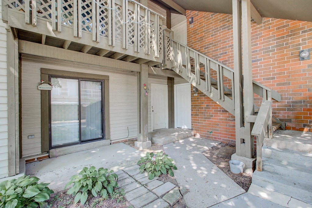 the front porch of an apartment building with a staircase