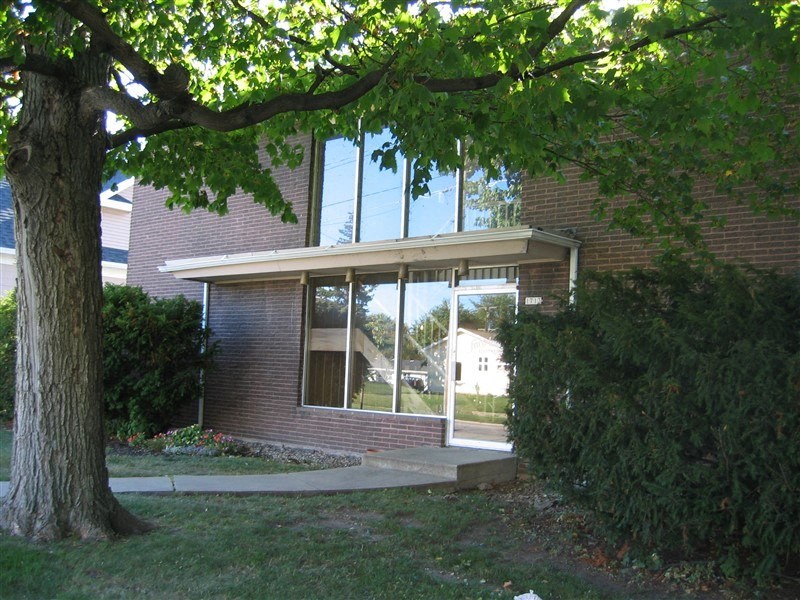 a large window in a brick building with a large tree in front of it