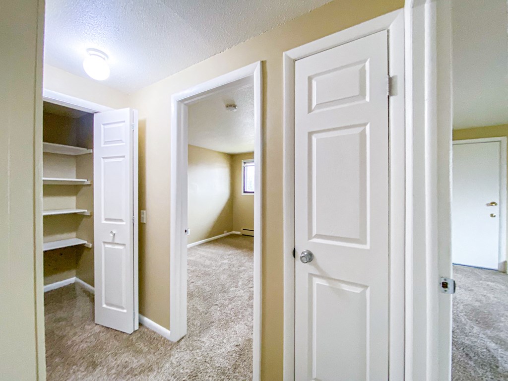 an empty bedroom and closet with a closet door open