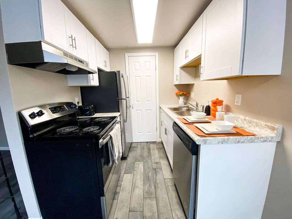 a kitchen with white cabinets and a black stove and refrigerator