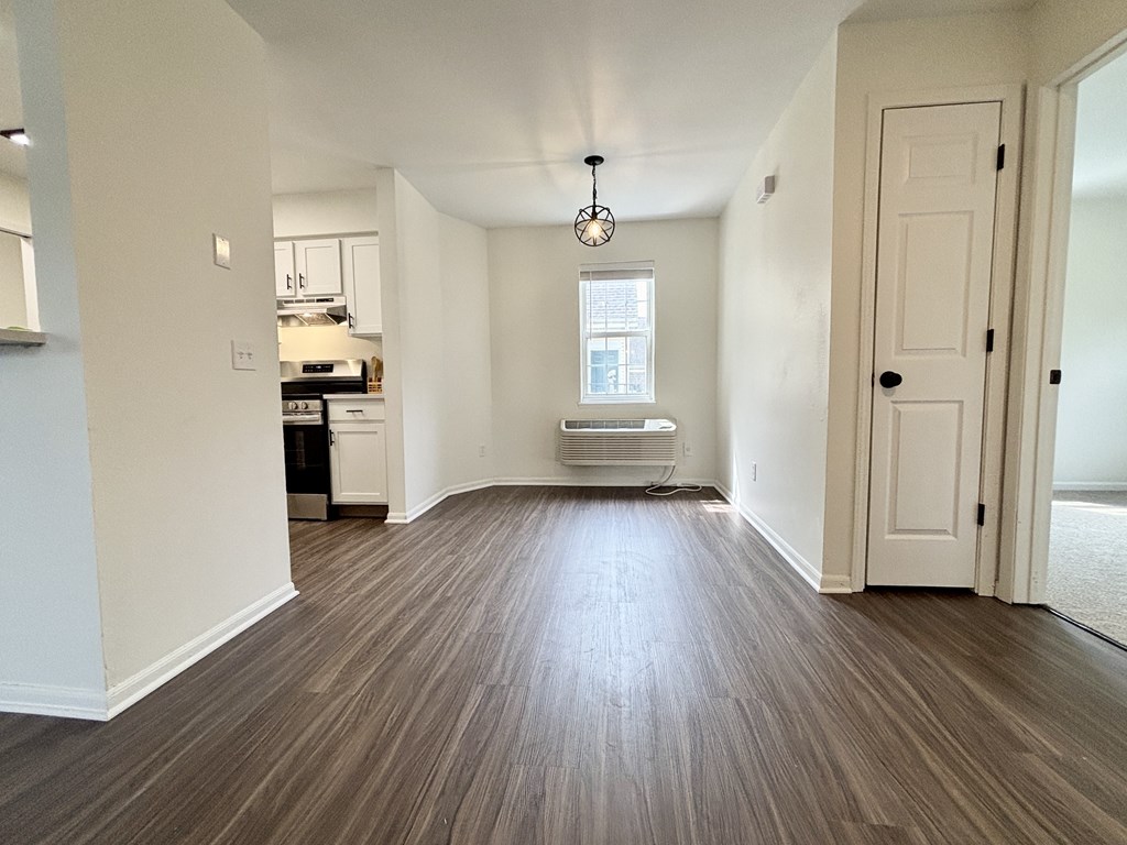 A room with wooden flooring and a white door.