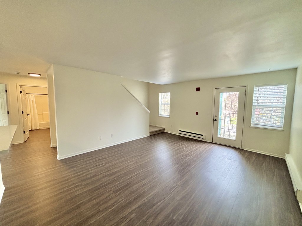 A room with wooden flooring and white walls.