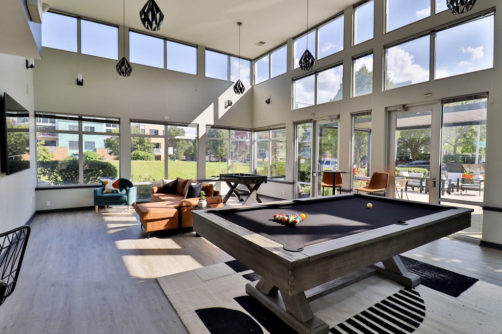 a large living room with a pool table in the middle