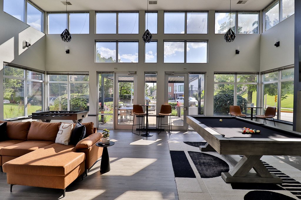 a large living room with a pool table and large windows