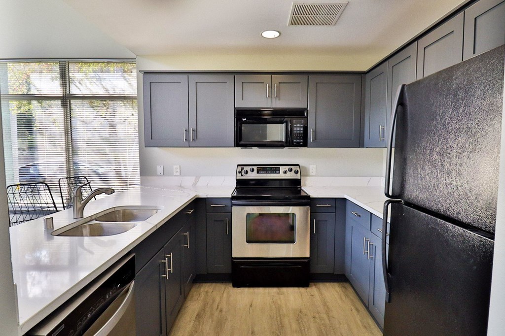 a kitchen with black appliances and white counter tops