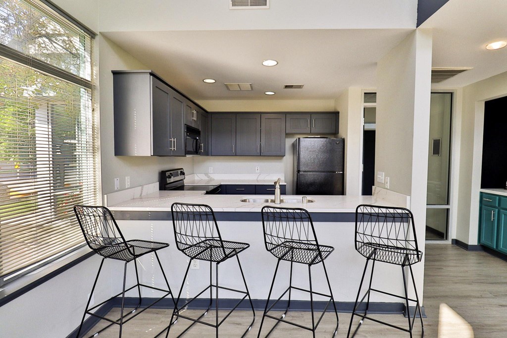 a kitchen with a counter and three bar stools