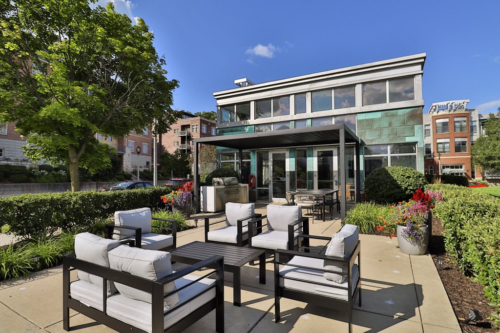 a patio with chairs and tables and a building in the background